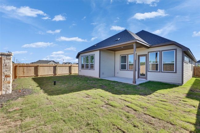 Rear view of property featuring a lawn, a patio area, a fenced backyard, and a shingled roof | Image 9