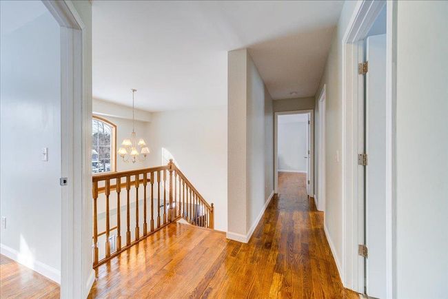 Hallway featuring an upstairs landing, a chandelier, wood finished floors | Image 29