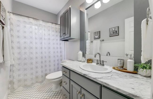 Full bathroom featuring a shower with curtain, toilet, and vanity | Image 24