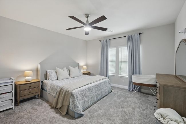Bedroom featuring baseboards, light carpet, visible vents, and a ceiling fan | Image 11