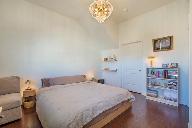 Bedroom with a chandelier, dark wood-style floors, and vaulted ceiling | Image 13