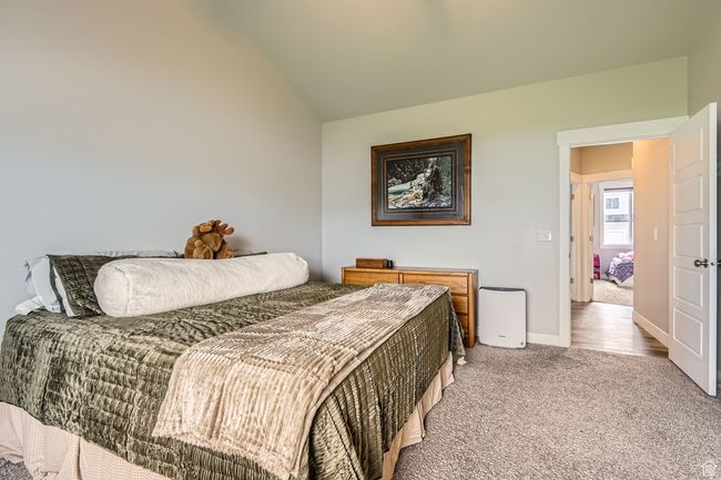 Bedroom with light carpet and lofted ceiling | Image 14