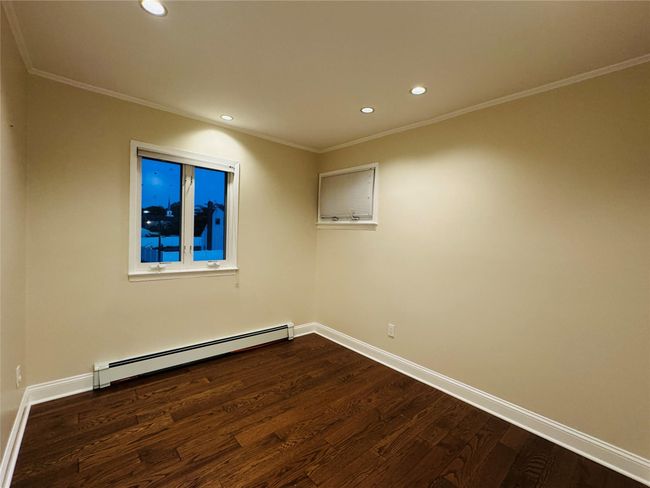 Bedroom featuring a baseboard heating unit, dark wood-style flooring, recessed lighting, and crown molding | Image 8