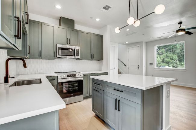 Kitchen with appliances with stainless steel finishes, a sink, light wood-style flooring, decorative backsplash, and recessed lighting | Image 5