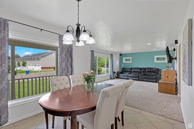 Dining area featuring a chandelier, light tile patterned flooring, recessed lighting, and baseboards | Image 11