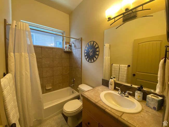 Bathroom featuring shower / bath combo with shower curtain, vanity, and toilet | Image 15