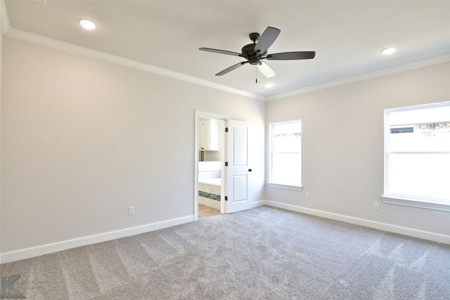Primary bedroom with carpet floors, crown molding, ceiling fan, and recessed lighting | Image 13