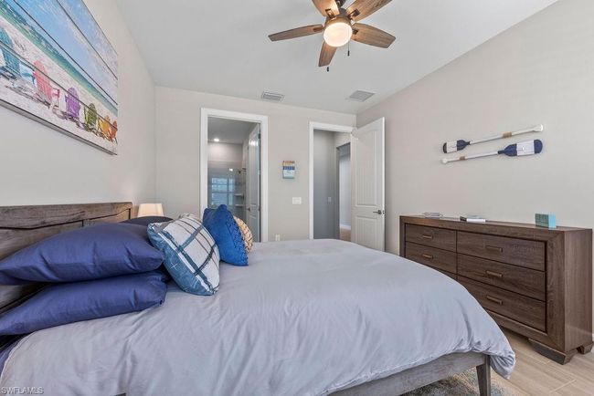 Bedroom featuring visible vents, light wood-style flooring, connected bathroom, and ceiling fan | Image 9
