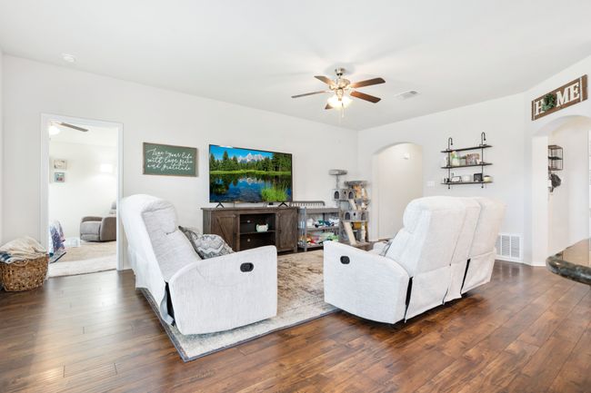 Living room featuring arched walkways, a ceiling fan, and dark wood finished floors | Image 15