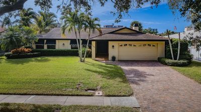 The front exterior of this property is a welcoming sight, adorned with a neatly manicured lawn and vibrant flowers, creating a charming curb appeal. | Image 2