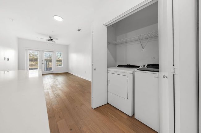 Laundry room featuring independent washer and dryer, light wood-style floors, baseboards, ceiling fan, and laundry area | Image 7