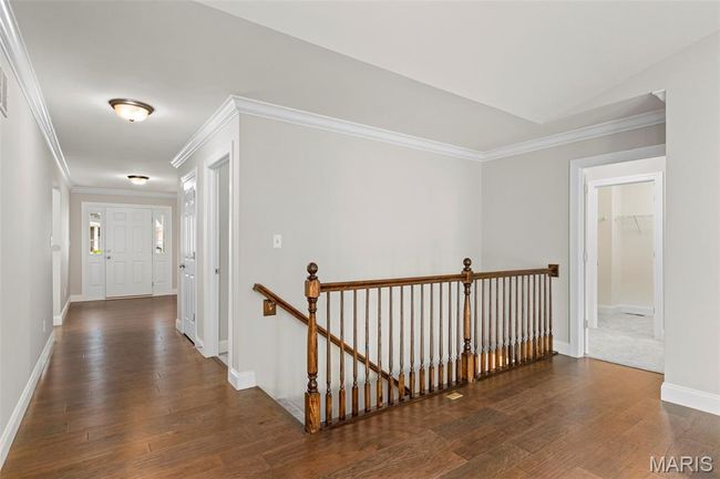 Hall featuring an upstairs landing, hardwood / wood-style floors, baseboards, and ornamental molding | Image 20