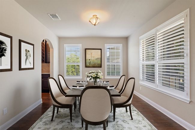 Dining room with wood floors and arched walkways | Image 6