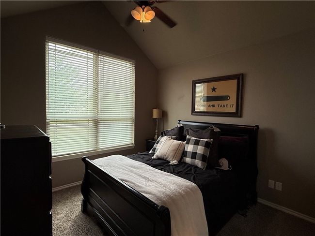Bedroom with carpet flooring, multiple windows, vaulted ceiling, and a ceiling fan | Image 16