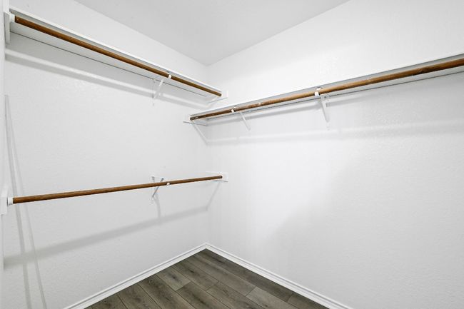 Walk in closet with dark wood-style flooring | Image 26