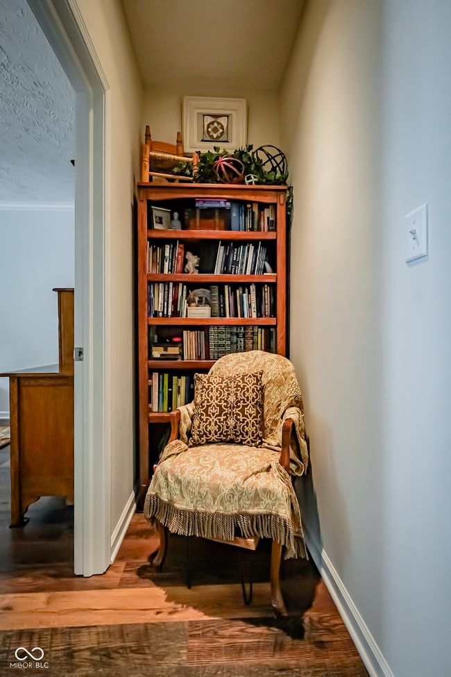 sitting room with wood finished floors, baseboards, and a textured ceiling | Image 14