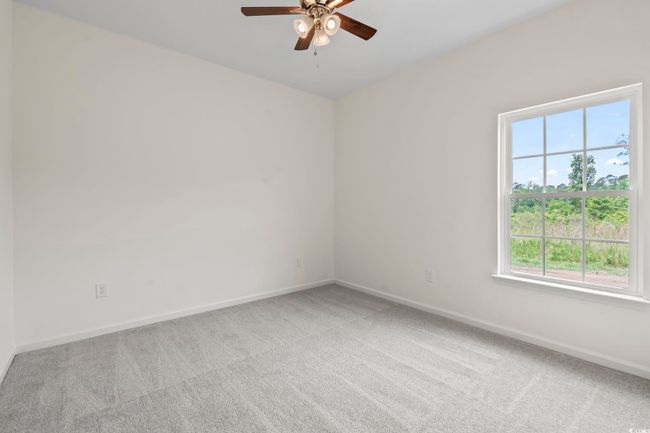 Unfurnished room featuring ceiling fan, light colored carpet, and baseboards | Image 12