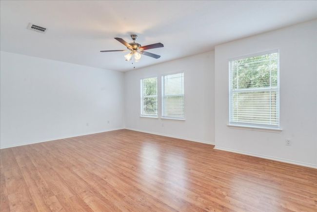 Upstairs features an oversized second living area or game room that’s open and bright with abundant natural light. It includes faux wood blinds, a new ceiling fan, and offers the perfect space for relaxing or a fun hangout spot for the kids. | Image 10