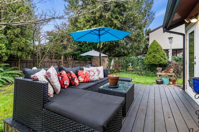Wooden deck with a fenced backyard and outdoor lounge area | Image 7