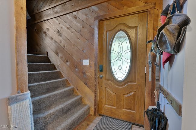 Foyer entrance featuring wooden walls, stairway, and light wood-style floors | Image 5