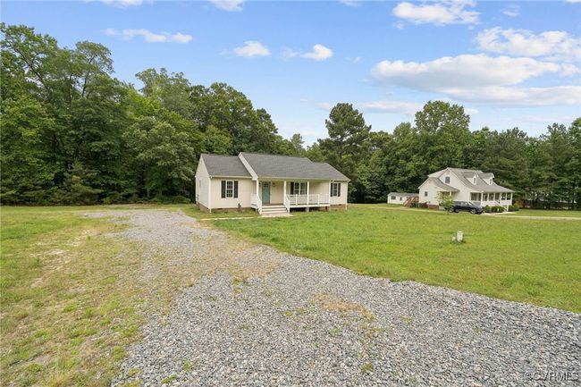 View of front of home with covered porch, driveway, and a front yard | Image 27