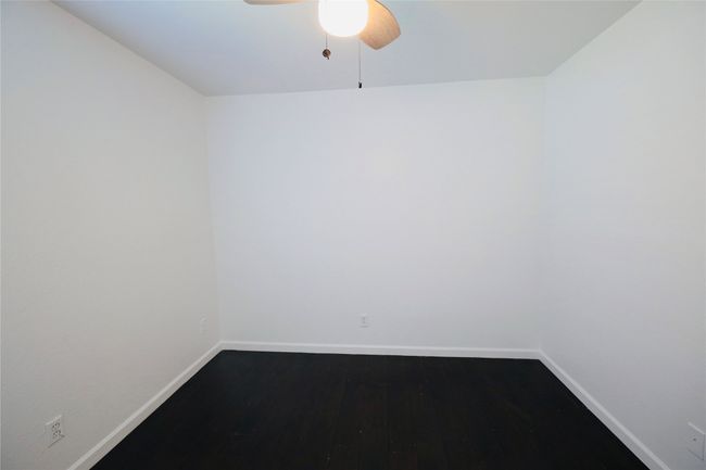 Bedroom with ceiling fan and dark wood-style floors | Image 21