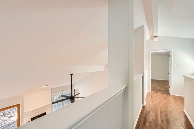 Hall featuring baseboards, wood finished floors, vaulted ceiling, and an upstairs landing | Image 20