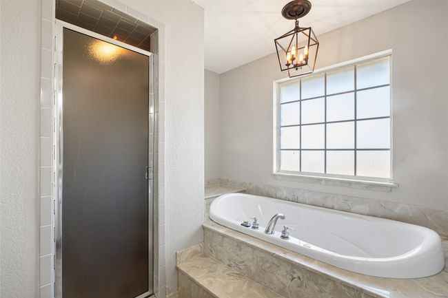 Full bath featuring a bath, a chandelier, and a stall shower | Image 17