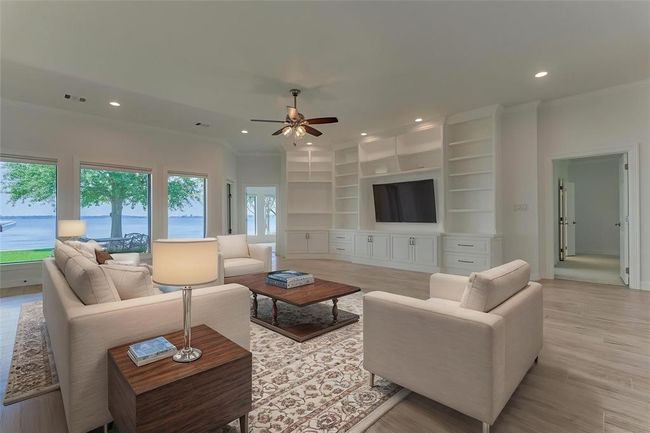 Looking back from the kitchen, you’re treated to stunning lake views and a glimpse of two thoughtfully designed primary suite areas, each offering comfort, privacy, and a seamless connection to the home’s surroundings. Photo is virtually staged to show furniture placement. | Image 20