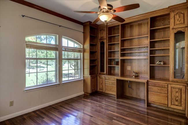 This quiet space to the left of the foyer offers options for work or study. Built-ins on two walls give you plenty of storage, use this space for work or transform it into a library. | Image 12