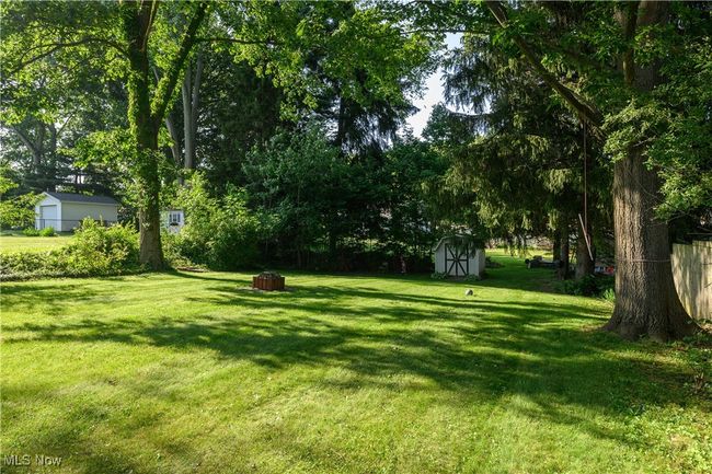 View of green lawn featuring a shed and view of scattered trees | Image 7
