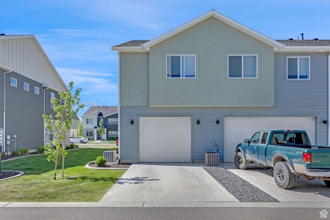 View of front of home featuring driveway, a front lawn, central AC, and a garage | Image 22