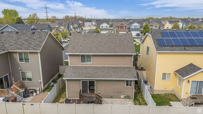 Back of house with a fenced backyard, roof with shingles, and a residential view | Image 29