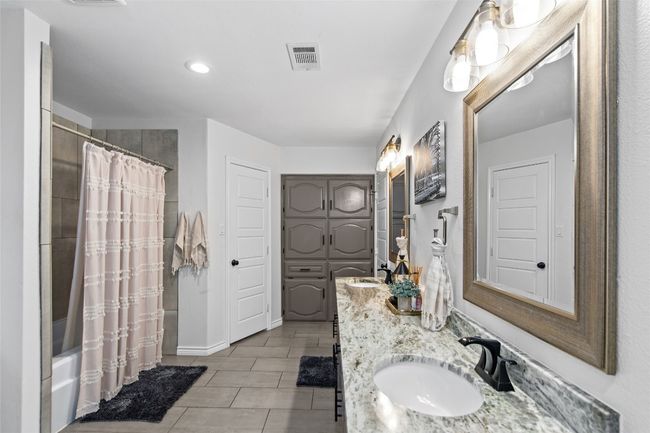 The primary bathroom features a granite vanity. | Image 18
