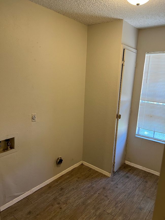 Laundry area with hookup for an electric dryer, washer hookup, a textured ceiling, dark wood finished floors, and baseboards | Image 15