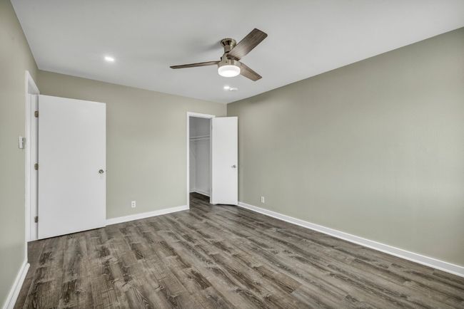 Unfurnished bedroom featuring dark wood-type flooring, baseboards, recessed lighting, ceiling fan, and a closet | Image 18