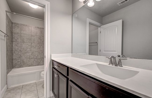 Bathroom with vanity, shower / tub combination, tile patterned floors, and a textured ceiling | Image 21