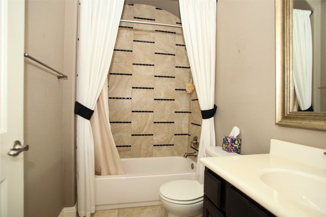 Bathroom with vanity, toilet, and shower / bathtub combination with curtain | Image 26