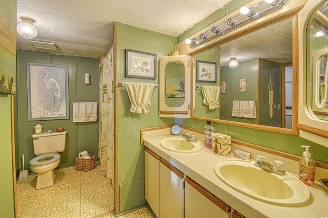 Bathroom featuring toilet, a textured ceiling, and vanity | Image 6