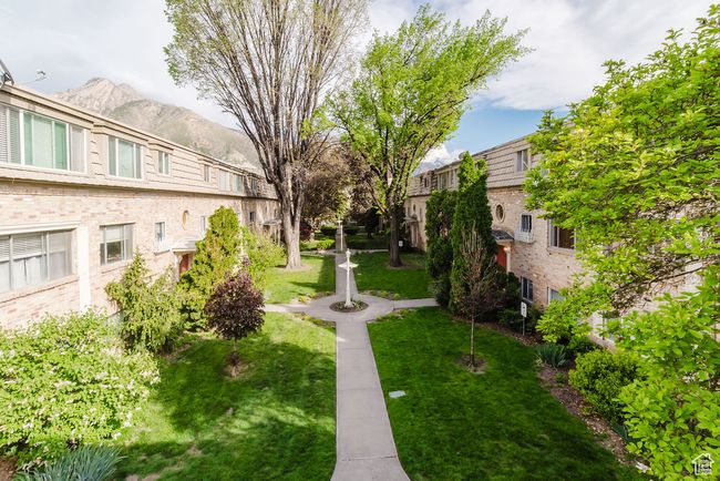 View of property's community featuring a mountain view and a lawn | Image 22