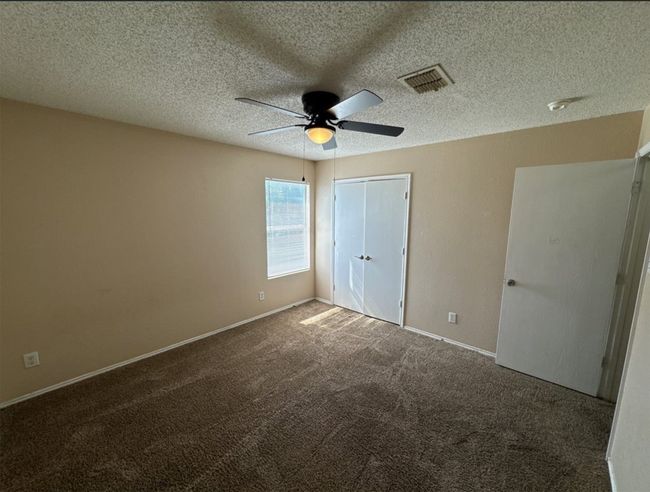 Unfurnished bedroom featuring a textured ceiling, ceiling fan, and carpet flooring | Image 15
