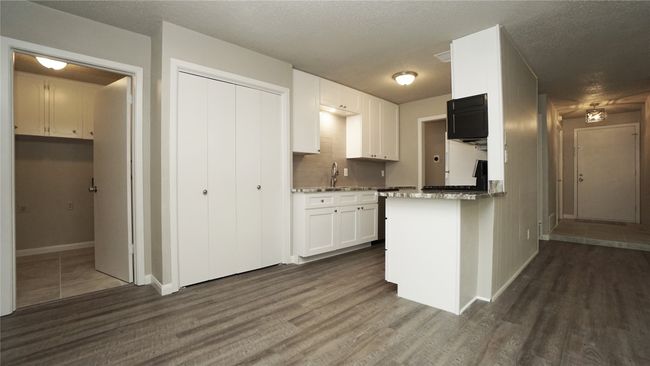 View of the kitchen, utility room, and double door pantry from the dining space | Image 7