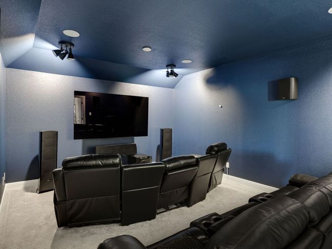 Home theater featuring carpet flooring, a textured wall, and lofted ceiling | Image 21