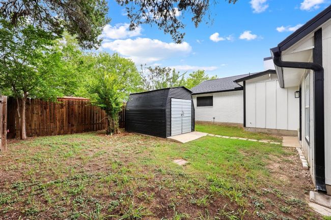 Fenced backyard featuring a storage shed | Image 29