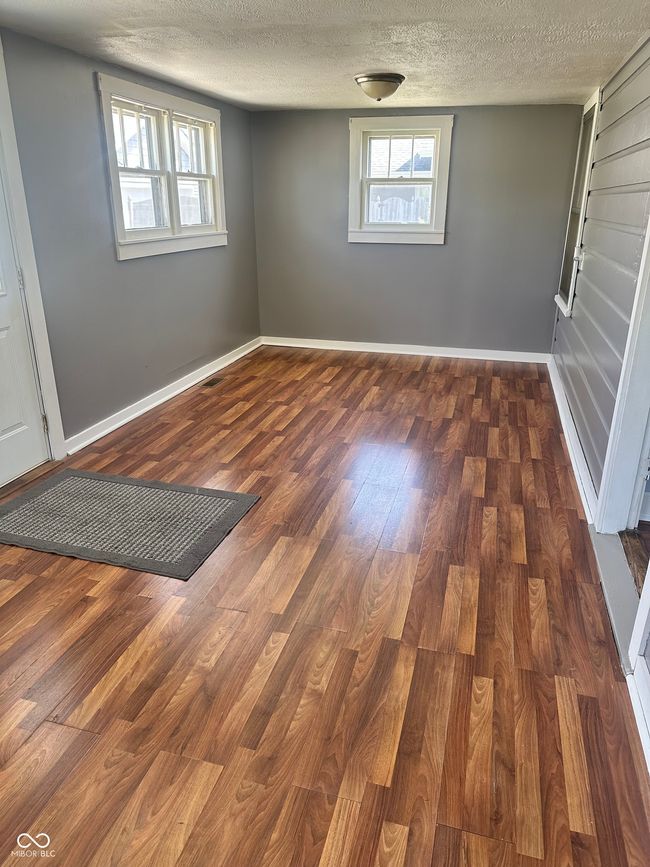 basement featuring baseboards, wood finished floors, and a textured ceiling | Image 12