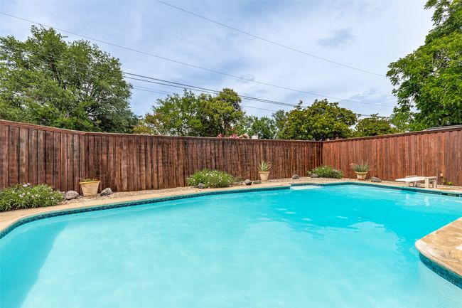 View of pool featuring a fenced backyard and a diving board | Image 5