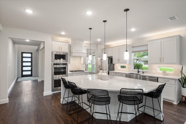 Kitchen has an oversized island with seating. | Image 14