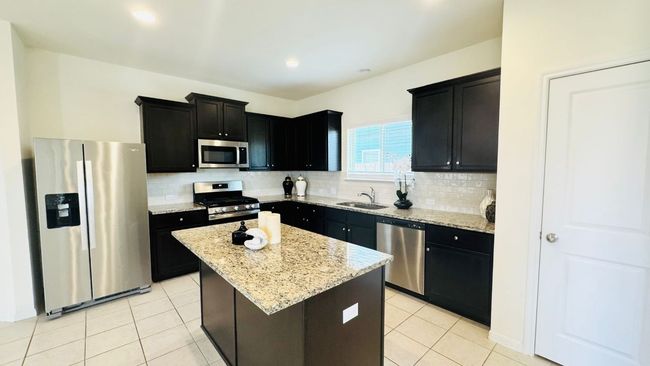 Kitchen with appliances with stainless steel finishes, dark cabinetry, decorative backsplash, and recessed lighting | Image 16