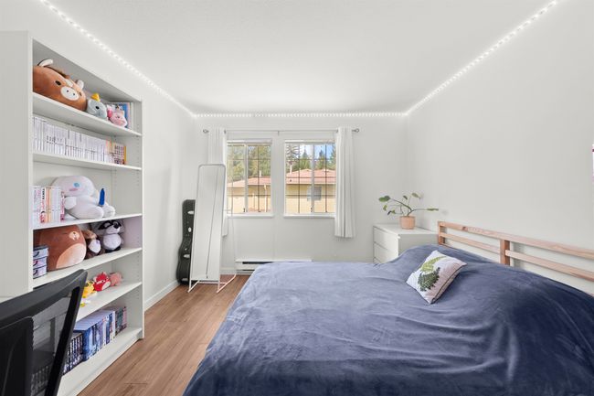 Bedroom with wood finished floors, a baseboard heating unit, and baseboards | Image 25