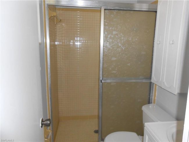 Bathroom with toilet, tiled shower, and vanity | Image 15